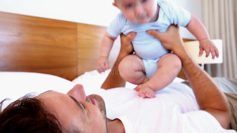 Padre feliz que miente con el hijo del bebé que despide en su pecho