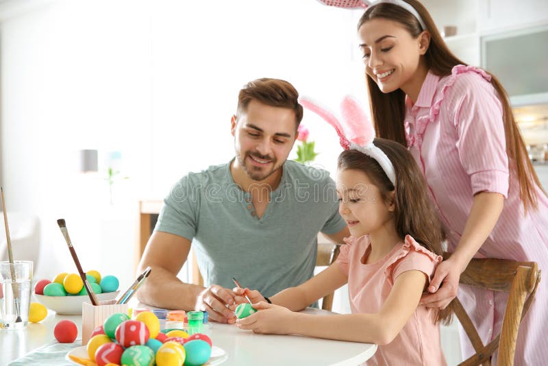 Padre, madre e hija pintando los huevos de Pascua en cocina fotografía de archivo libre de regalías Padre, madre e hija pintando los huevos de Pascua en cocina fotografía de archivo libre de regalías