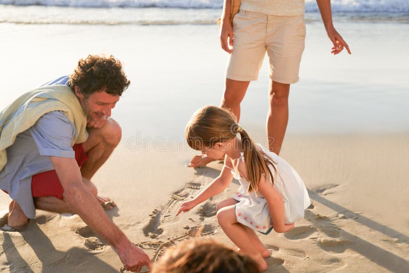 Padre ragazza e disegno in sabbia in spiaggia con vacanze di famiglia o sorriso con legame di creatività. papà bambini e fotografia stock