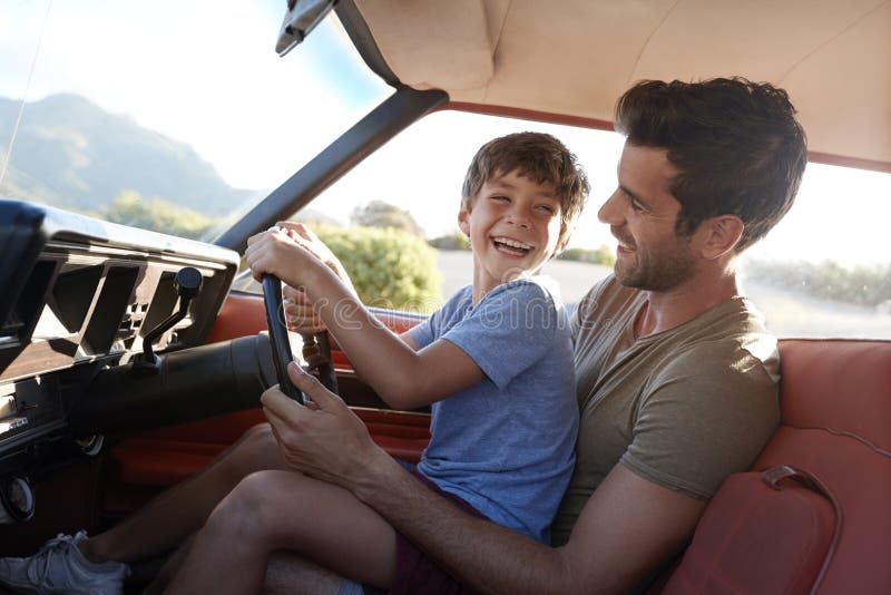 Padre Teaching Young Son para conducir el coche en viaje por carretera fotografía de archivo Padre Teaching Young Son para conducir el coche en viaje por carretera fotografía de archivo