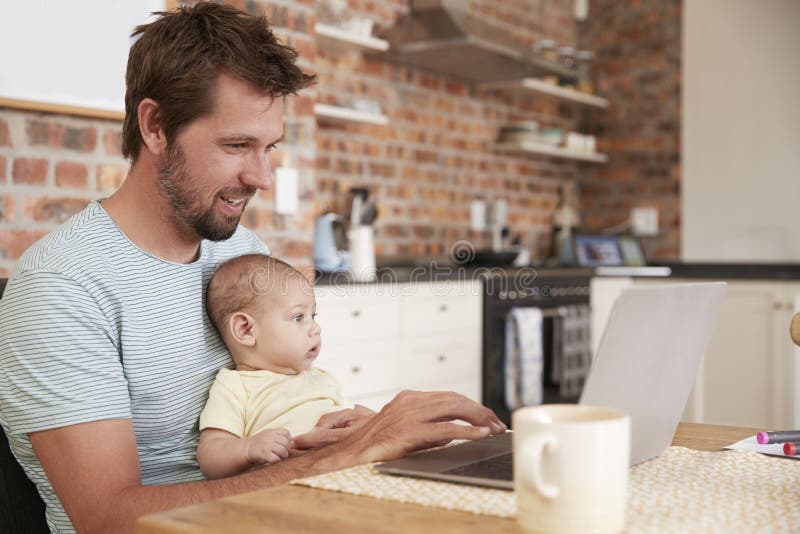 Padre Working From Home en el ordenador portátil con el hijo del bebé imágenes de archivo libres de regalías