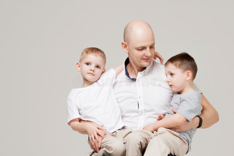 Padre y sus dos hijos, el hombre joven que cría a niños fotografía de archivo Padre y sus dos hijos, el hombre joven que cría a niños fotografía de archivo