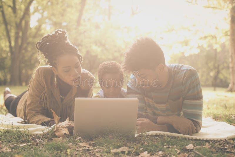 Padres afroamericanos con su hija en parque fotografía de archivo libre de regalías Padres afroamericanos con su hija en parque fotografía de archivo libre de regalías