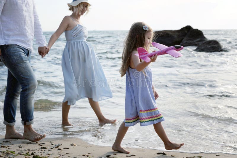 Padres futuros de la familia feliz con caminar cerca del mar foto de archivo Padres futuros de la familia feliz con caminar cerca del mar foto de archivo