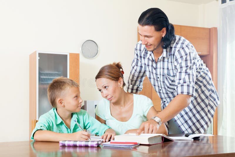 Padres que ayudan a adolescente con la preparación imagenes de archivo Padres que ayudan a adolescente con la preparación imagenes de archivo