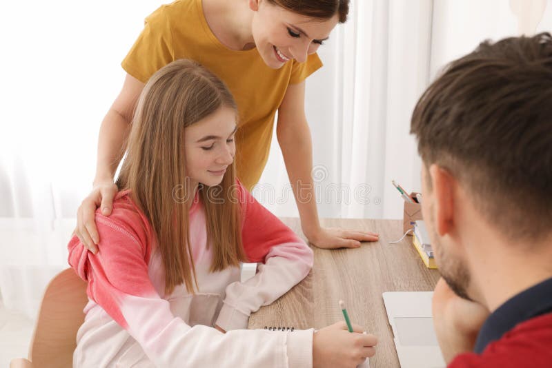 Padres que ayudan a su hija del adolescente con la preparaci?n foto de archivo Padres que ayudan a su hija del adolescente con la preparaci?n foto de archivo