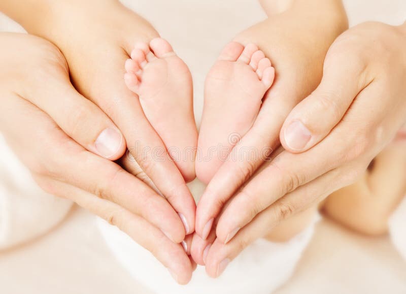 Padres recién nacidos de los pies del bebé que se sostienen en manos. fotografía de archivo Padres recién nacidos de los pies del bebé que se sostienen en manos. fotografía de archivo