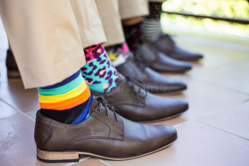 Groomsmen showing off colorful socks before wedding ceremony. Groomsmen showing off colorful socks before wedding ceremony