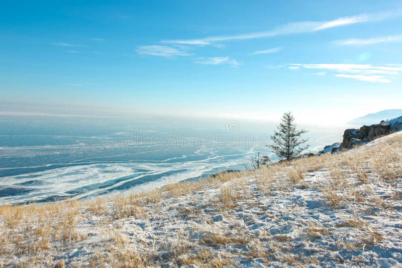 Paesaggio del lago Baikal congelato nell'inverno con la nuvola ed il cielo blu; punto di vista da capo all'isola di Olkhon fotografie stock Paesaggio del lago Baikal congelato nell'inverno con la nuvola ed il cielo blu; punto di vista da capo all'isola di Olkhon fotografie stock