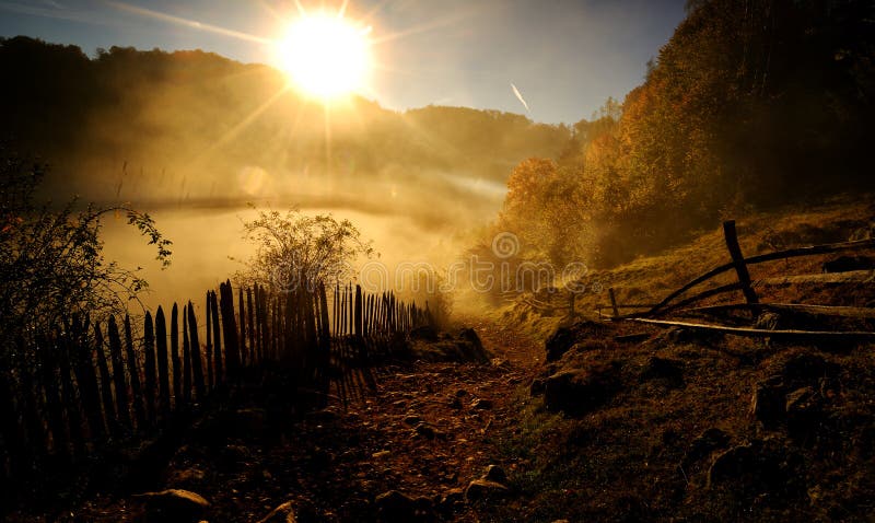 Paesaggio della montagna con la nebbia di mattina di autunno ad alba