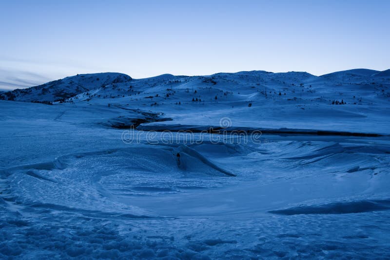 Paesaggio della montagna di inverno Lago congelato coperto di neve e di ghiaccio all'ora blu Diga Belmeken nell'inverno, Bulgaria immagine stock Paesaggio della montagna di inverno Lago congelato coperto di neve e di ghiaccio all'ora blu Diga Belmeken nell'inverno, Bulgaria immagine stock