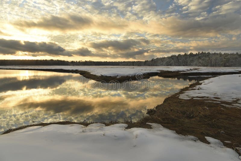 Paesaggio di inverno del fiume al tramonto e della foresta nella distanza sull'orizzonte fotografie stock libere da diritti Paesaggio di inverno del fiume al tramonto e della foresta nella distanza sull'orizzonte fotografie stock libere da diritti