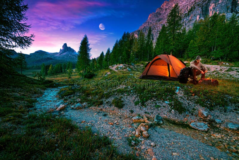 Paesaggio mistico di notte, nell'aumento della priorità alta, nel fuoco di accampamento e nella tenda