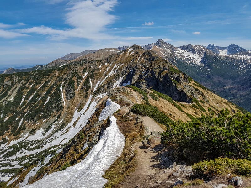 Paesaggio scenico del parco nazionale di Tatra con le montagne nel giorno di molla soleggiato con il villaggio vicino di Zakopane fotografia stock Paesaggio scenico del parco nazionale di Tatra con le montagne nel giorno di molla soleggiato con il villaggio vicino di Zakopane fotografia stock