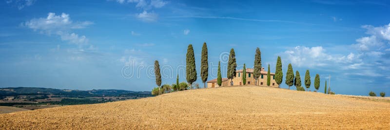 Paesaggio tipico di un'azienda agricola con una fila degli alberi di cipresso in Toscana Italia immagini stock libere da diritti Paesaggio tipico di un'azienda agricola con una fila degli alberi di cipresso in Toscana Italia immagini stock libere da diritti