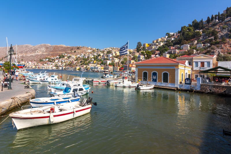 Paesaggio urbano un giorno soleggiato, isole di Dodecanese, Grecia della città di Symi immagini stock Paesaggio urbano un giorno soleggiato, isole di Dodecanese, Grecia della città di Symi immagini stock