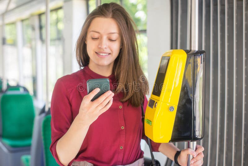 Pagamento femminile della donna conctactless con lo smartphone il trasporto pubblico nel tram immagini stock libere da diritti Pagamento femminile della donna conctactless con lo smartphone il trasporto pubblico nel tram immagini stock libere da diritti