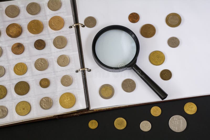 Loupe Et L'album Avec Une Collection De Pièces De Monnaie Sur Un