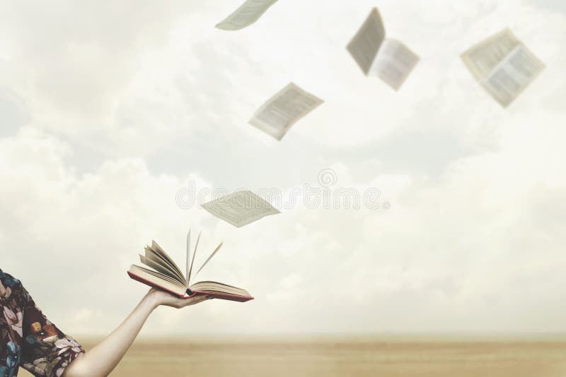 Pages fly free in the sky from a book held open by a woman