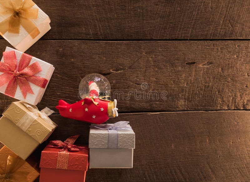 Pagina di natale dei contenitori di regalo e del globo di Santa sul fondo di legno dello scrittorio e spazio vuoto per testo Vist fotografie stock Pagina di natale dei contenitori di regalo e del globo di Santa sul fondo di legno dello scrittorio e spazio vuoto per testo Vist fotografie stock