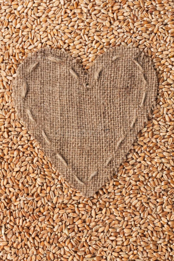 Pagina sotto forma di cuore fatto di tela da imballaggio con grano fotografia stock libera da diritti Pagina sotto forma di cuore fatto di tela da imballaggio con grano fotografia stock libera da diritti