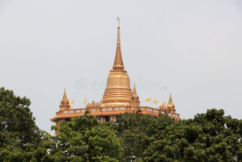Pagoda looking through the treetops. The Golden Mount is a replica of a mountain pagoda situated in the Wat Saket temple. Bangkok