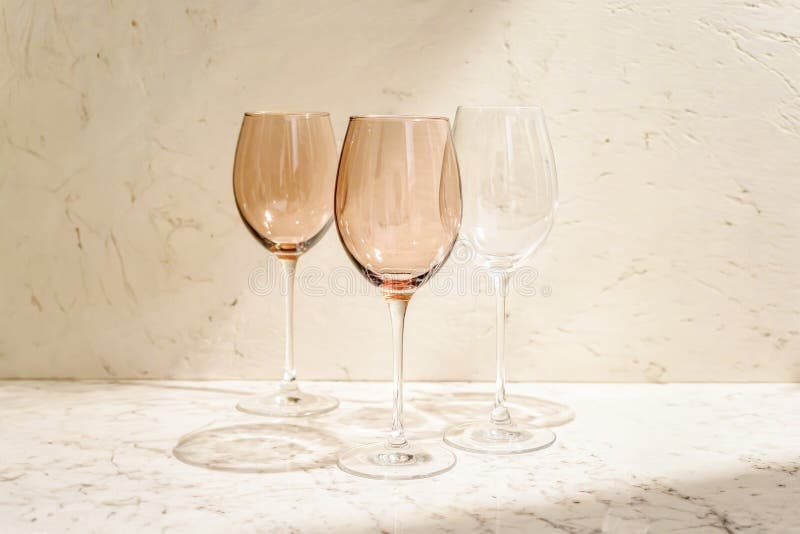 Pahare elegante de vin, cu lumină solară caldă, pe suprafața marmură royalty free stock photo