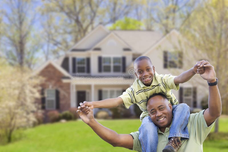 Playful African American Father and Son In Front Yard of Home. Playful African American Father and Son In Front Yard of Home.