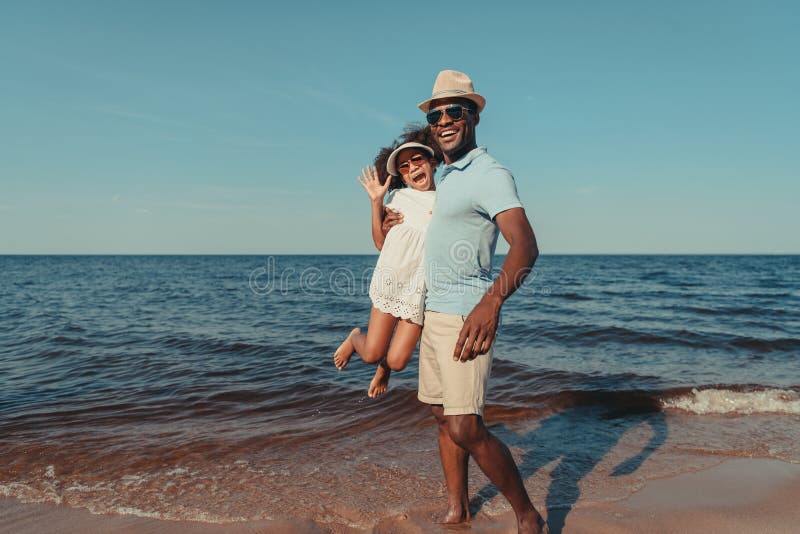 pai afro-americano de sorriso e filha pequena bonito nos óculos de sol que têm o divertimento junto imagens de stock royalty free pai afro-americano de sorriso e filha pequena bonito nos óculos de sol que têm o divertimento junto imagens de stock royalty free