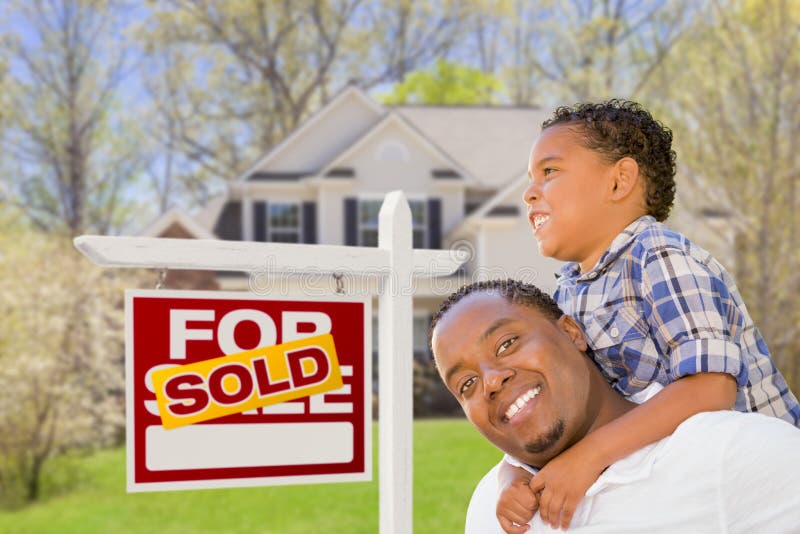 Happy Mixed Race Father and Son In Front of Sold Real Estate Sign and New House. Happy Mixed Race Father and Son In Front of Sold Real Estate Sign and New House.