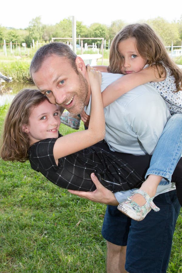 Pai do retrato e filha dois na felicidade na parte externa no dia de verão do prado imagens de stock Pai do retrato e filha dois na felicidade na parte externa no dia de verão do prado imagens de stock