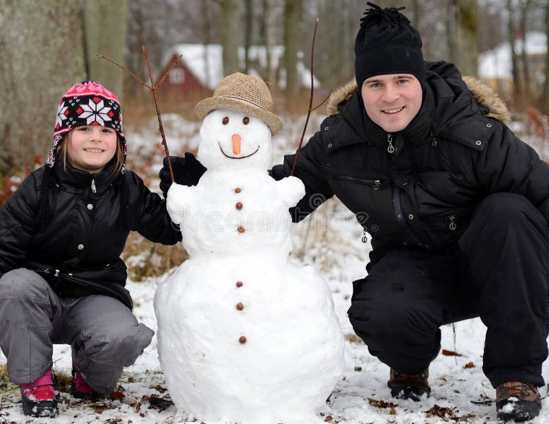 Pai e filha com boneco de neve imagem de stock royalty free