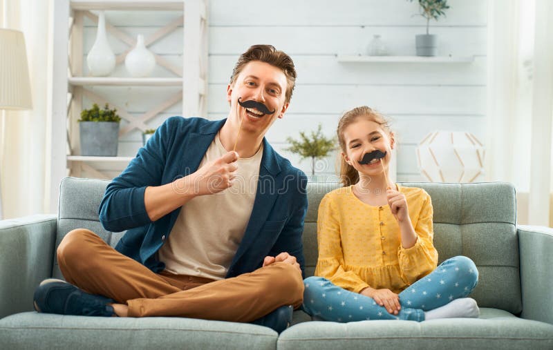 Pai e filha com o bigode na vara fotografia de stock Pai e filha com o bigode na vara fotografia de stock