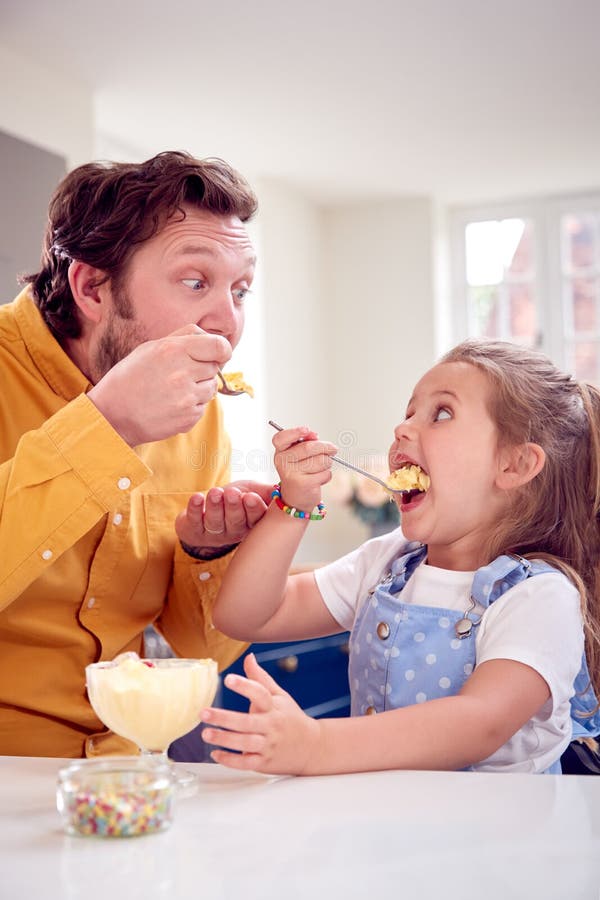 Pai e filho comem sobremesa com sementes de chia e mangas à beira