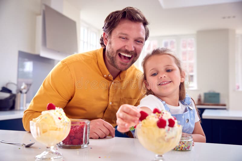 Pai e filho comem sobremesa com sementes de chia e mangas à beira