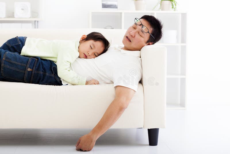 Pai e filha que dormem no sofá imagens de stock Pai e filha que dormem no sofá imagens de stock