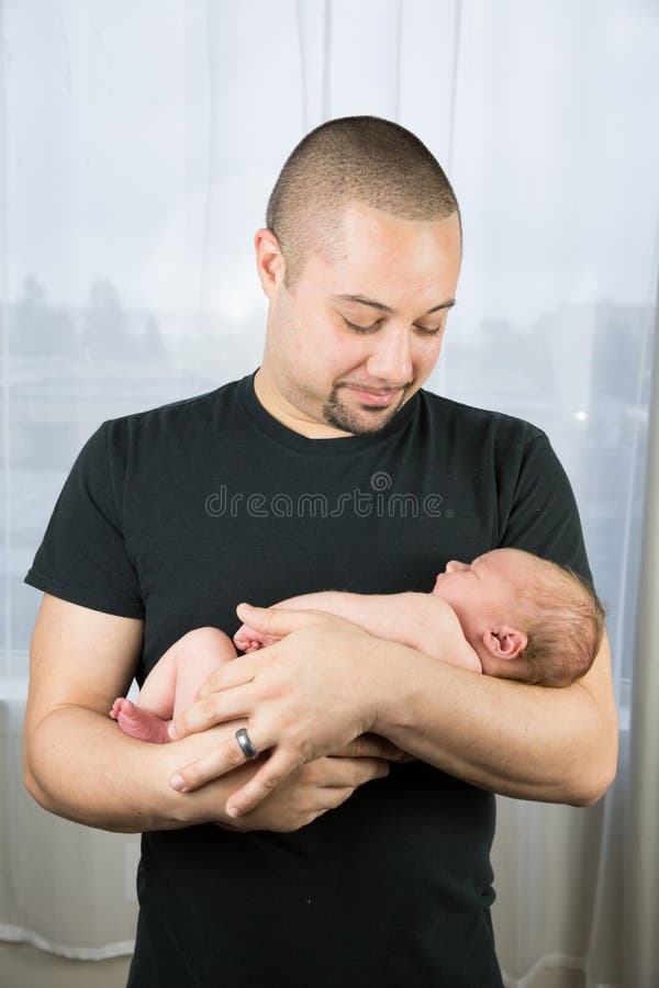 A new father holds his newborn son. A new father holds his newborn son.