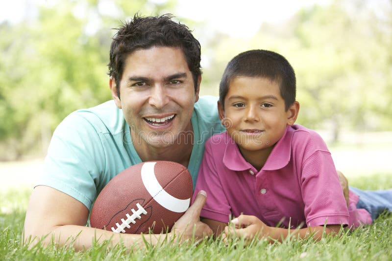Pai e filho no parque com futebol americano