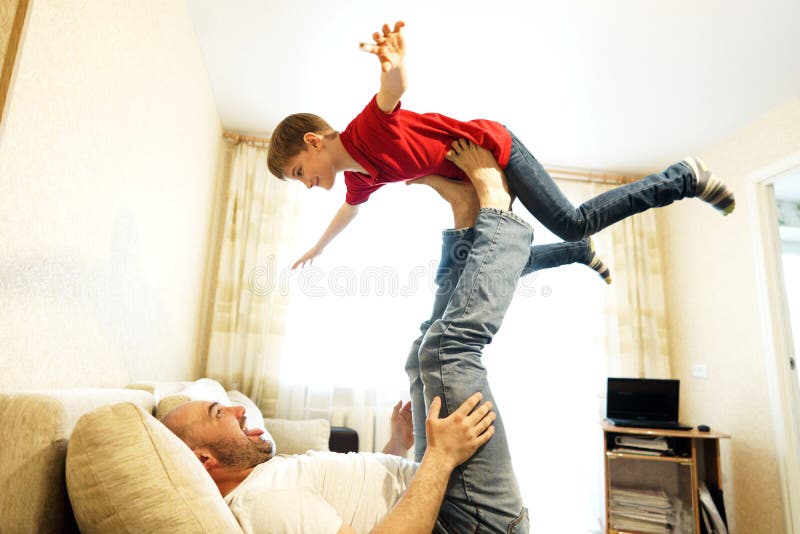 Pai e filho que jogam no sofá no avião imagens de stock royalty free Pai e filho que jogam no sofá no avião imagens de stock royalty free