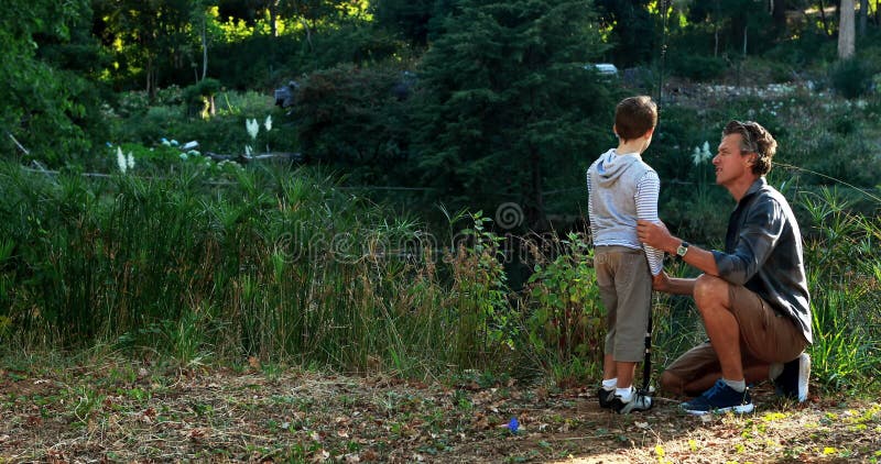 Pai e filho que olham a natureza no parque