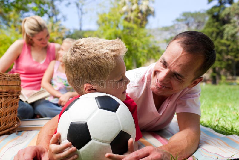 Pai e filho que prendem uma esfera de futebol imagens de stock royalty free Pai e filho que prendem uma esfera de futebol imagens de stock royalty free