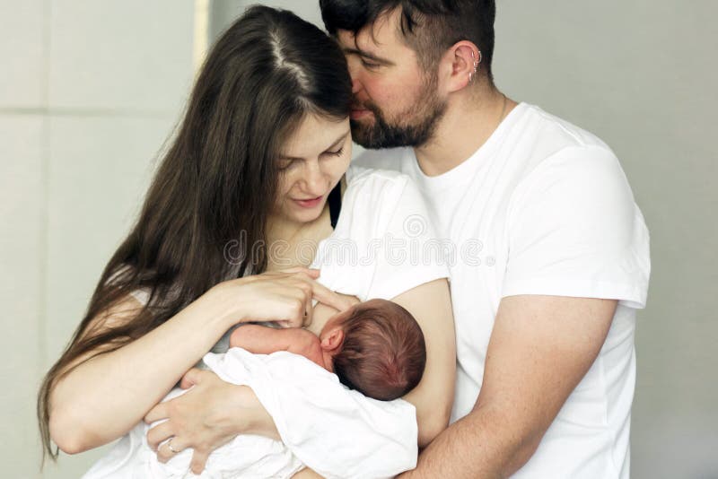 Father and mother with a newborn son. New young multi-generation family. Breast-feeding. Father and mother with a newborn son. New young multi-generation family. Breast-feeding