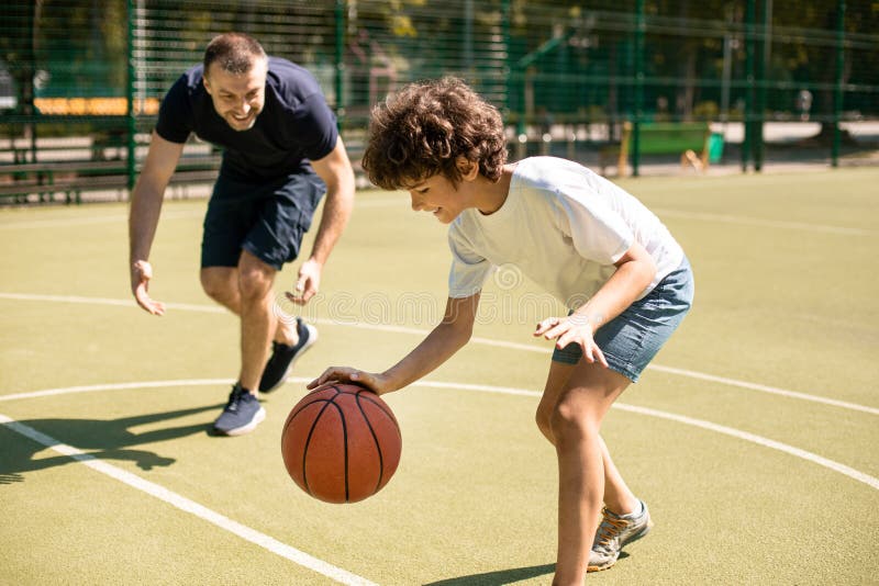 Esportivo Ensinando Garoto a Jogar Basquete Lá Fora Foto de Stock - Imagem  de atividade, objetivo: 216416036