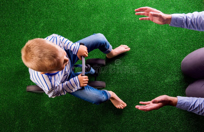 Pai irreconhecível que trava seu filho que monta uma bicicleta imagens de stock Pai irreconhecível que trava seu filho que monta uma bicicleta imagens de stock