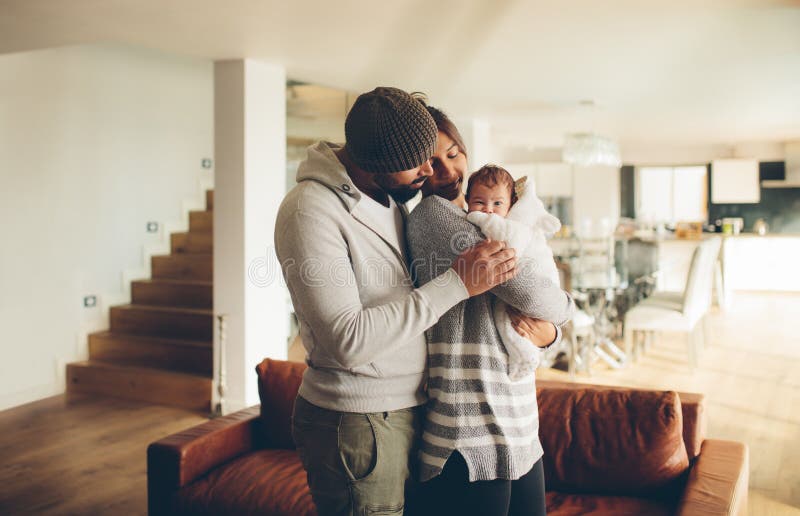 Pai novo e mãe que guardam seu bebê imagem de stock Pai novo e mãe que guardam seu bebê imagem de stock