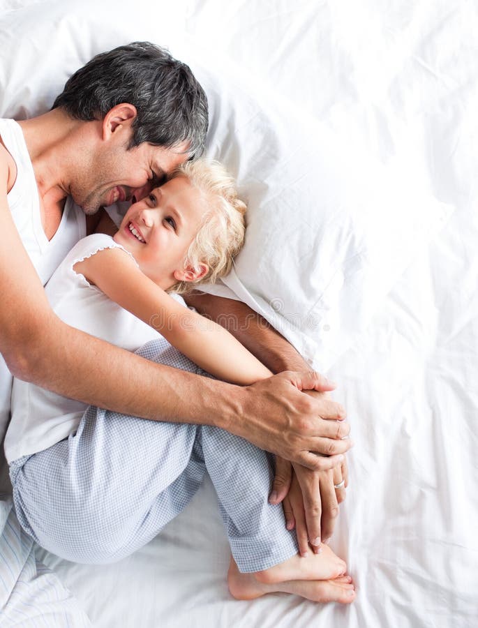 Download Pai Que Huggling Sua Filha Na Cama Foto de Stock - Imagem de menina, abraçar: 10067180