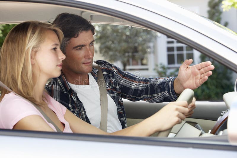 Pai Teaching Teenage Daughter a conduzir foto de stock Pai Teaching Teenage Daughter a conduzir foto de stock