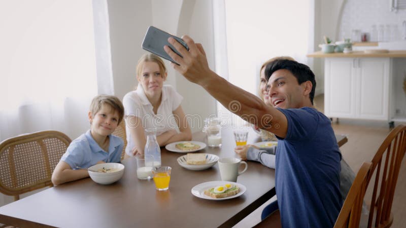 Pai tomando selfie enquanto toma café da manhã