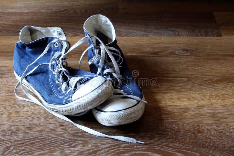 Paia degli stivali blu e bianchi degli istruttori delle scarpe da tennis su fondo di legno con spazio per testo immagini stock libere da diritti Paia degli stivali blu e bianchi degli istruttori delle scarpe da tennis su fondo di legno con spazio per testo immagini stock libere da diritti