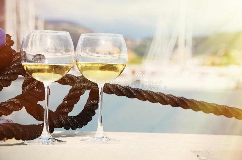 Paia dei bicchieri di vino contro gli yacht fotografia stock libera da diritti